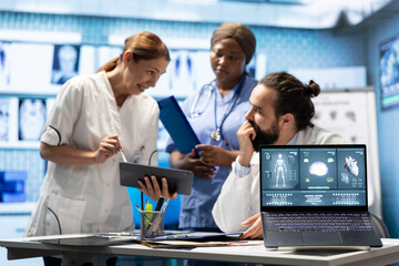 Fototapeta premium Doctors cardiologist analyze human anatomy scans to check heart condition in a treatment center. Team of licensed specialists working together to provide diagnostic and insurance services.