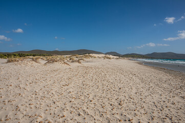 The beautiful beach of Is Solinas in Sardinia with its high white dunes on a windy day