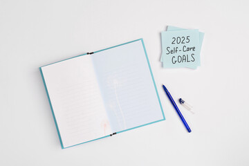 Paper note with words 2025 Self Care Goals on a white minimal background. Concept of goals and...