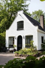 A delightful white house nestled amidst lush greenery on a bright sunny day, boasting a beautifully maintained garden and a cozy patio ideal for relaxation