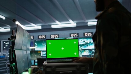Army specialist working in war room operating surveillance tech, evaluating target data on isolated...