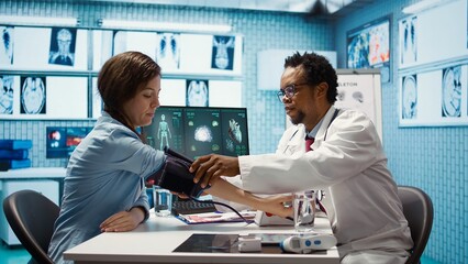 Fototapeta premium Medical expert taking the pulse and blood pressure with a blood pressure monitor during check up visit, healthcare industry. Physician using modern diagnostic tools for cardiology. Camera B.