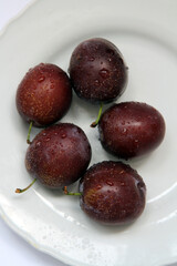 Fresh plums on the white plate