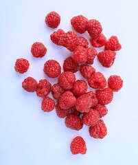 Red raspberries on white background with space for copy