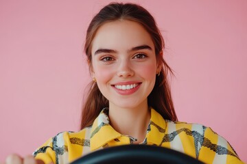 Image of a cheerful young woman with brown hair driving a new car against a pink backdrop