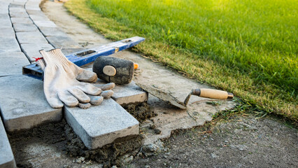 Laying paving stones on cement mortar. Laying a garden path made of tiles. Self-laying of concrete paving slabs in the courtyard of the house. do it yourself. DIY