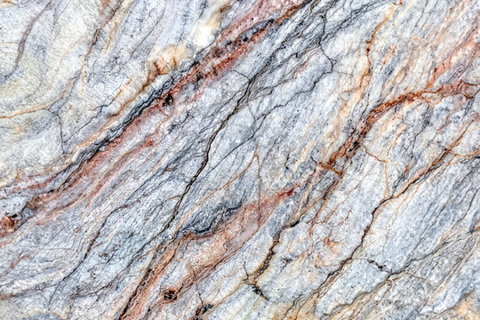 Close-up of natural marble with detailed gray, white, and pink veins, showcasing an elegant and intricate stone texture
