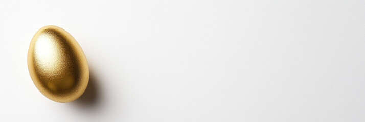 Fototapeta premium A shiny golden egg on clean white background, perfect for celebrations