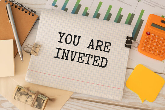 businessman holding a card with text YOU ARE INVETED