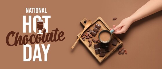 Female hand with cup of tasty drink, spoon and cocoa beans on brown background. Banner for National Hot Chocolate Day