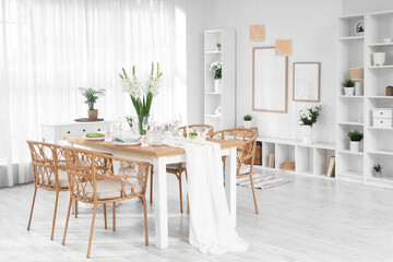 Stylish table setting with vase of Gladiolus flowers near window in kitchen