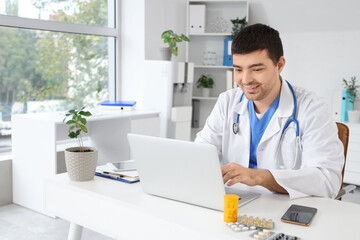 Male doctor working on laptop in  clinic