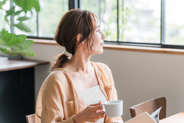 コーヒーを飲みながら読書・本を読む女性（自分時間・ミータイム・カフェ・家）

