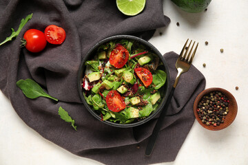 Bowl of tasty avocado salad with cherry tomatoes and peppercorns on white background