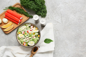 Bowl of salad with crab sticks, iceberg leaves, corn, quail eggs and cucumber on grey grunge background © Pixel-Shot