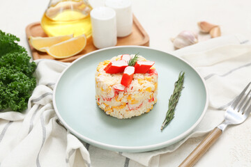 Plate of salad with crab sticks, corn and rosemary on light grunge background