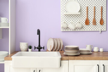 Clean plates near sink in stylish kitchen, closeup