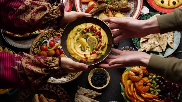 Hummus Ramadan food, Iftar time, People at the table. Authentic Middle Eastern local homemade meals in traditional dishes