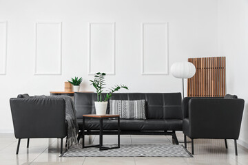 Interior of stylish living room with modern black armchairs, sofa and coffee table