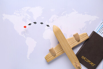 Wooden airplane with passport and arrows on map. Itinerary concept
