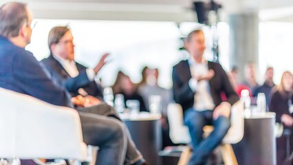 Leadership Panel Discussion Blur – A blurred background of a leadership panel discussion with industry leaders speaking.
