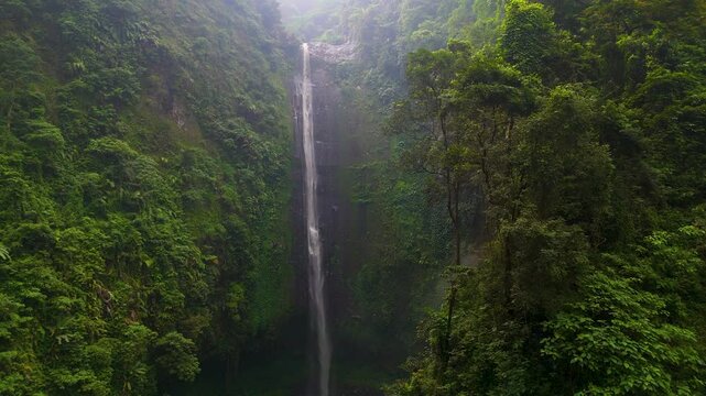 Drone view Madakaripura Waterfall - spectacular waterfall lies hidden at the end of a deep valley in the foothills of the Tengger mountain range, East Java, Surabaya, Indonesia