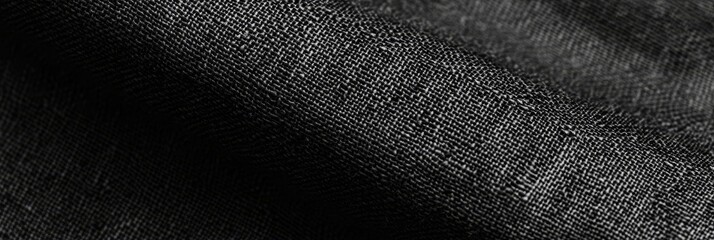Close-up of black fabric texture with subtle folds and weaves.