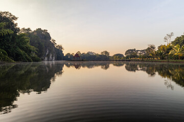 Obraz premium Morning Serenity: Pavilion on Water Amidst Cliffs at Wat Suwannakuha