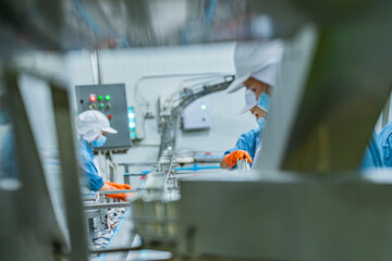 Skilled technician in a food factory handling canned products, highlighting efficiency, strict hygiene, and quality assurance in the food processing industry.