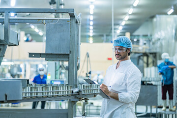 Naklejka premium quality assurance scientist Food production factory technician inspecting automated machinery and products wearing protective gear in industrial facility ensuring standards and food safety compliance.