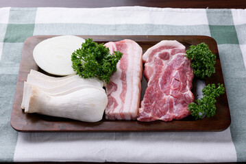 On a brown plate, there are onions, mushrooms, pork, and parsley.