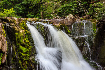 A waterfall with a lot of moss growing on it