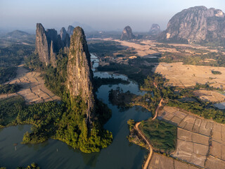 Fototapeta premium Beautiful nature with rocky mountains, lake and rice field by drone 