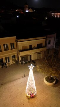 Riprese aeree della piazza di Teulada con l'albero di natale comunale ricco di regali. 