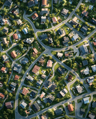 Aerial view of a suburban neighborhood with winding roads and houses surrounded by greenery.