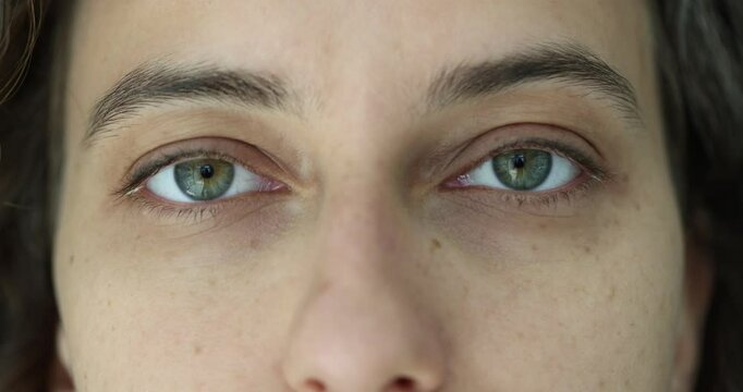 Closeup of bright sad green eyes of a woman