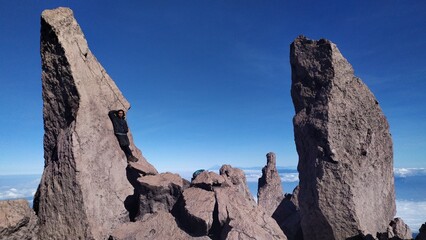 Climber is next to a large rock in mountain