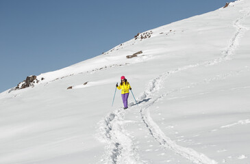 Independent Woman Trekking Alone Through Snow-Covered Mountain Pass With Poles