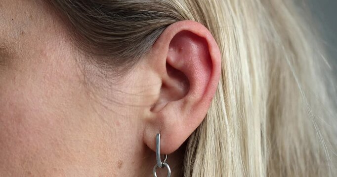Closeup of ear with hoop earring showing natural features of ear