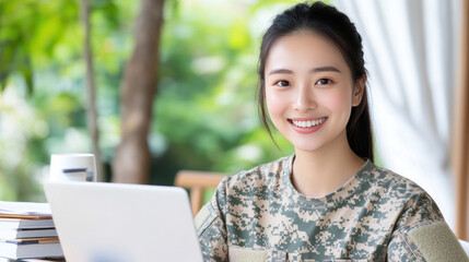Chinese woman in army uniform smiling, working with a laptop at tent