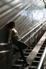 Portrait of a young Asian woman posing in the subway near the stairs. 