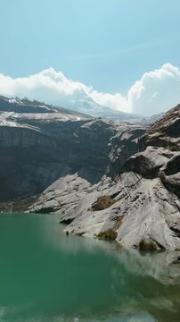 Aerial of Green Lagoon near Laguna 513 with Snow-Capped Mountain and Clouds, Vertical Fly-Over