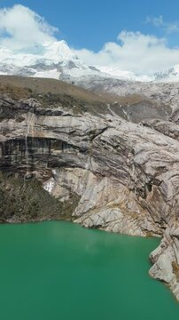 Aerial of Green Lagoon near Laguna 513 with Snow-Capped Mountains and Waterfall, Vertical Pan