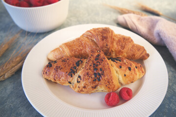 Fresh croissants and raspberries on the table