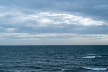 雲と水平線が続く広い海
