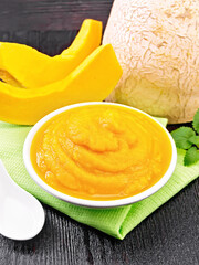 Pumpkin puree in plate on wooden board