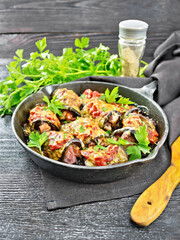 Rolls of eggplant with meat in pan on dark board
