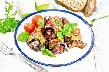 Rolls of eggplant with meat in plate on light board