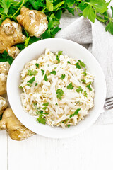 Salad of Jerusalem artichoke and eggs in plate on light board top