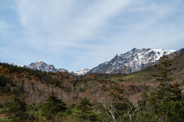 Obraz premium 冠雪した白馬岳と紅葉する栂池高原をハイキングする